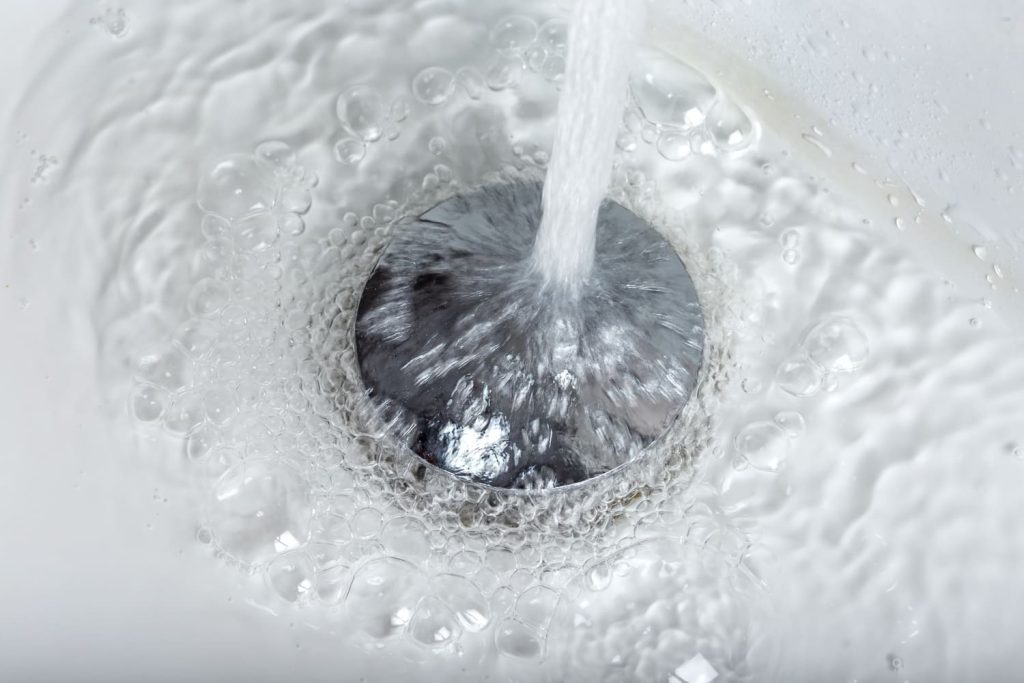 Image of a slow-moving drain indicating a potential clog, drain cleaning