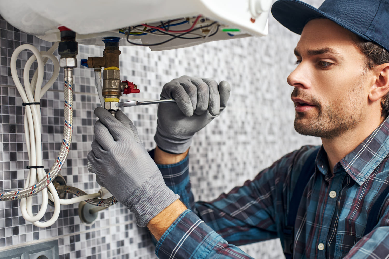 Professional using tools to repair a water heater
